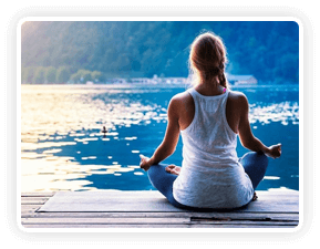 A person sitting in calm meditation on the beach at sunset